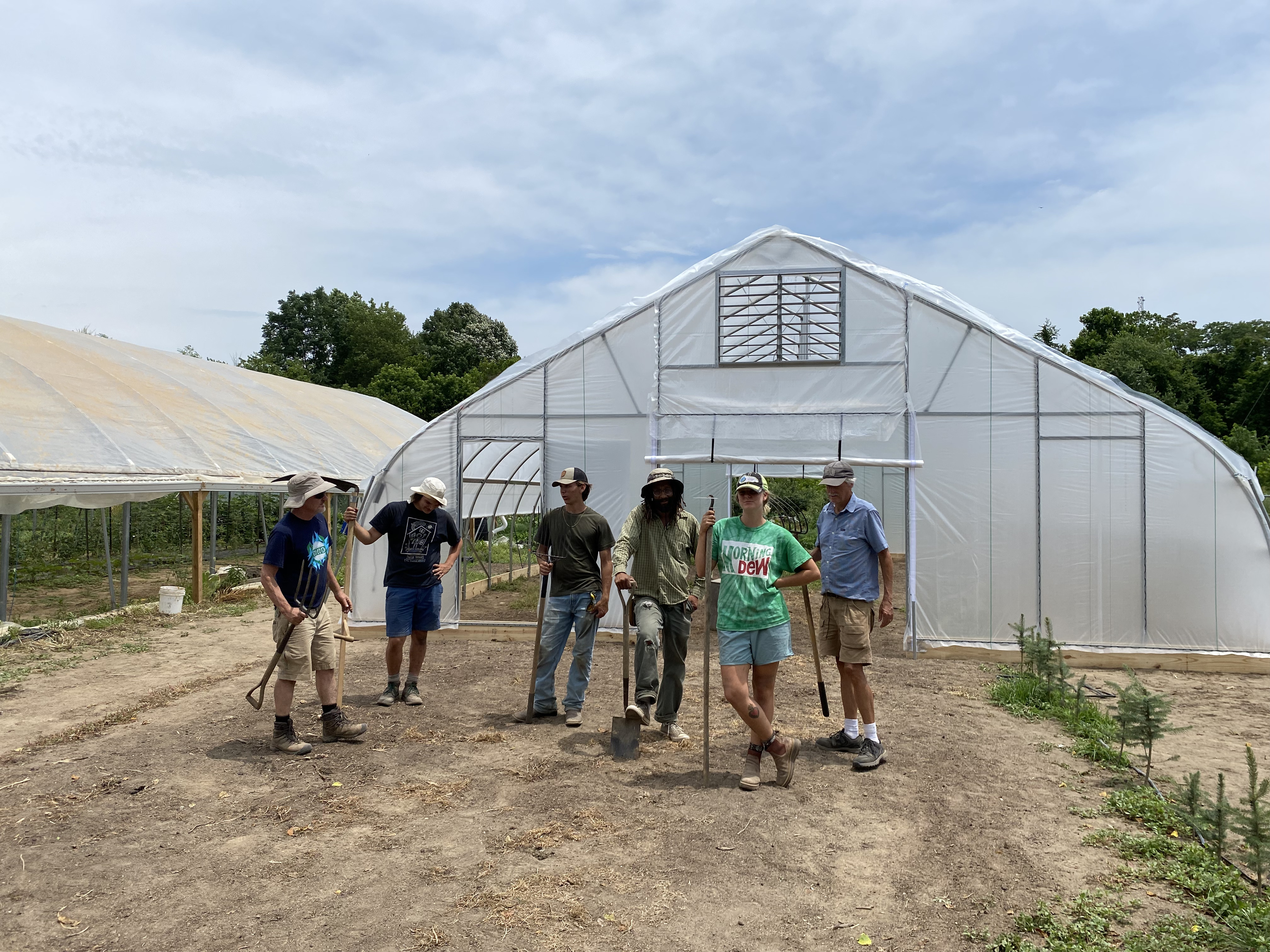 Farmers working around their new nifty hoops hoop house